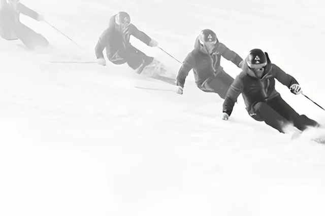 Skiërs in een carvebocht tijdens een training van Skitraining.nl